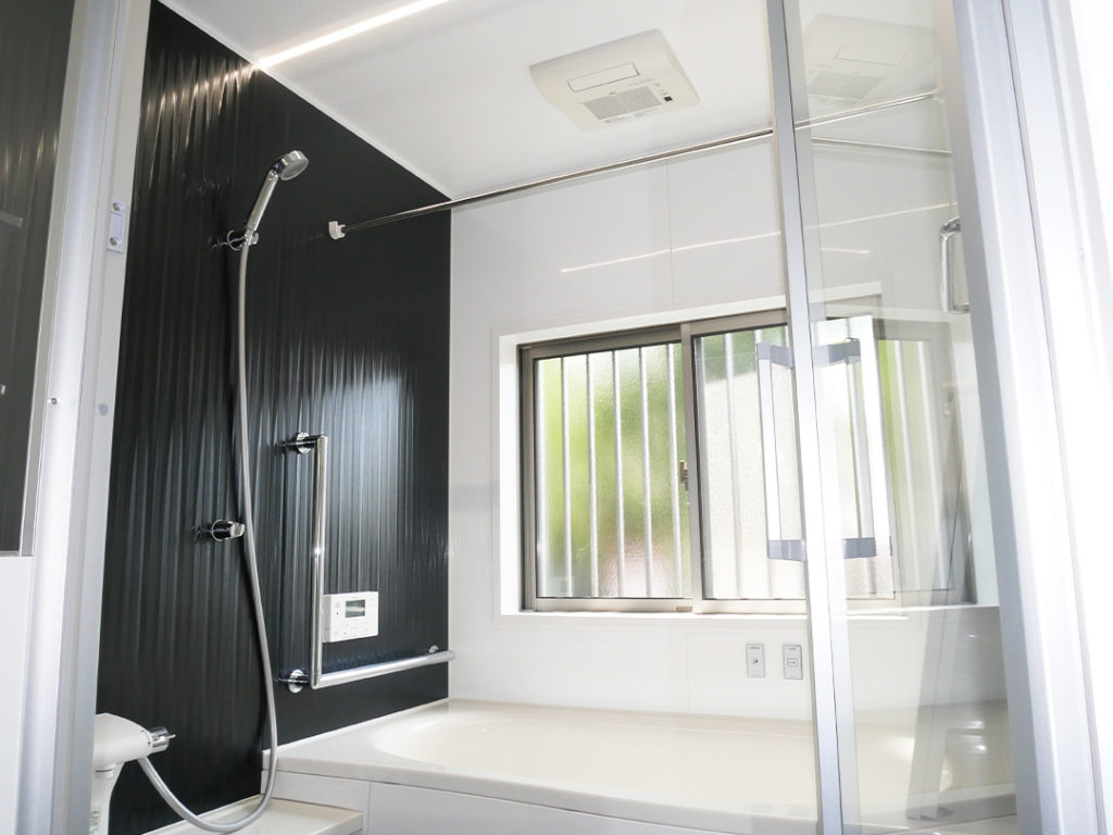 浴室は在来工法から、システムバスに交換したことでゆったりできます。増築した空間に脱衣所を作り、浴室を独立させました。パネルは落ち着いたブラックで高級感が出ます。